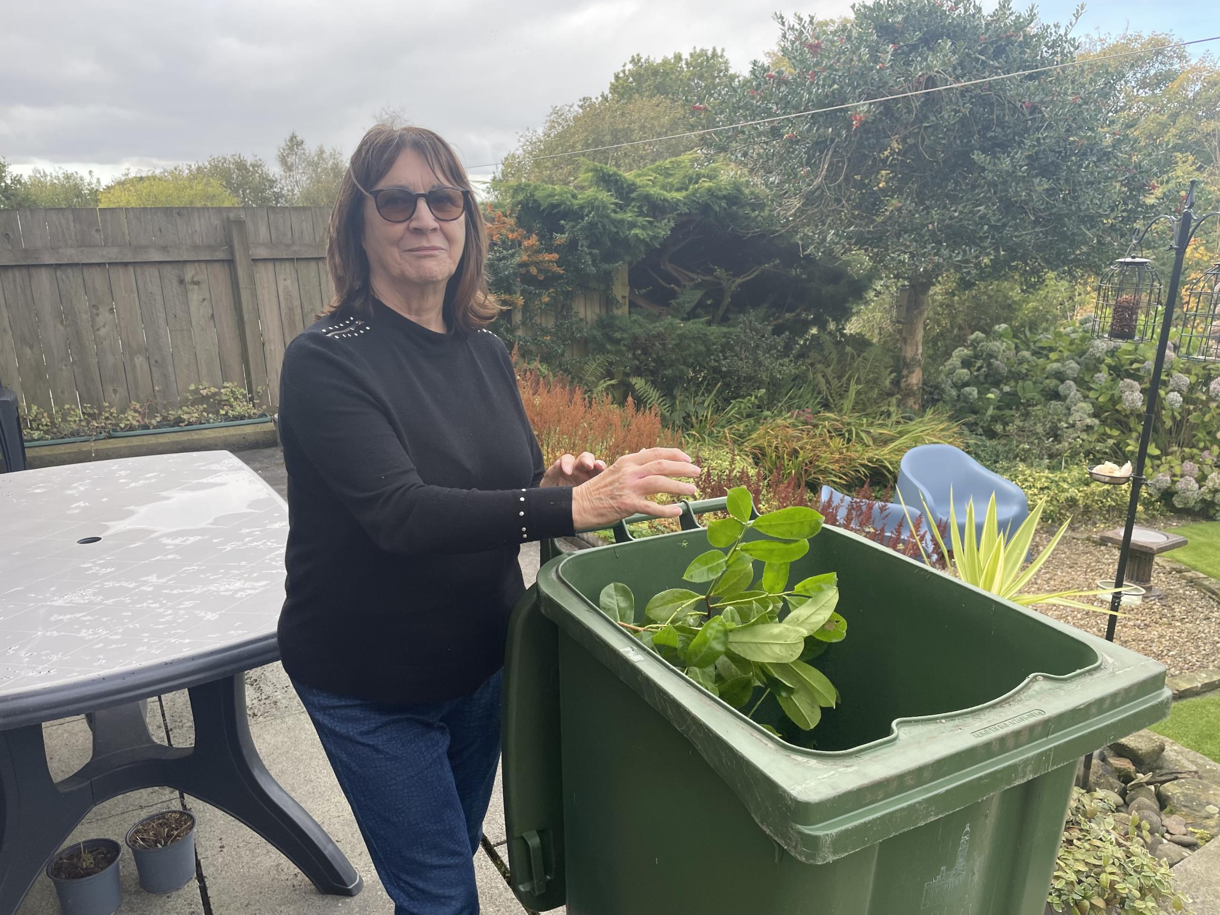 Margaret Stevens fills her green garden waste bin before most collections